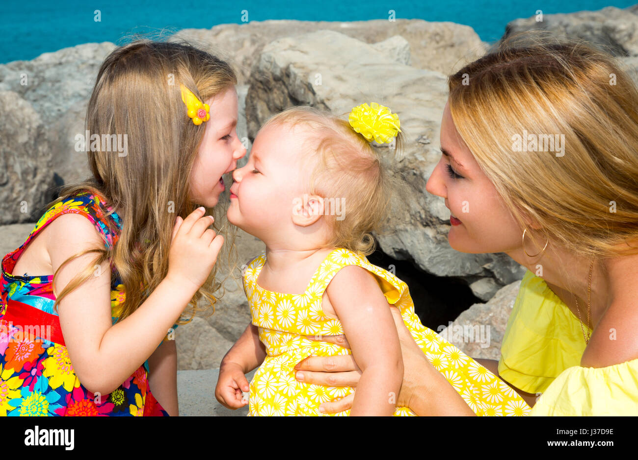 Happy mom and children girls hugging. The concept of childhood and family. Beautiful Mother and her baby daughter outdoor Stock Photo