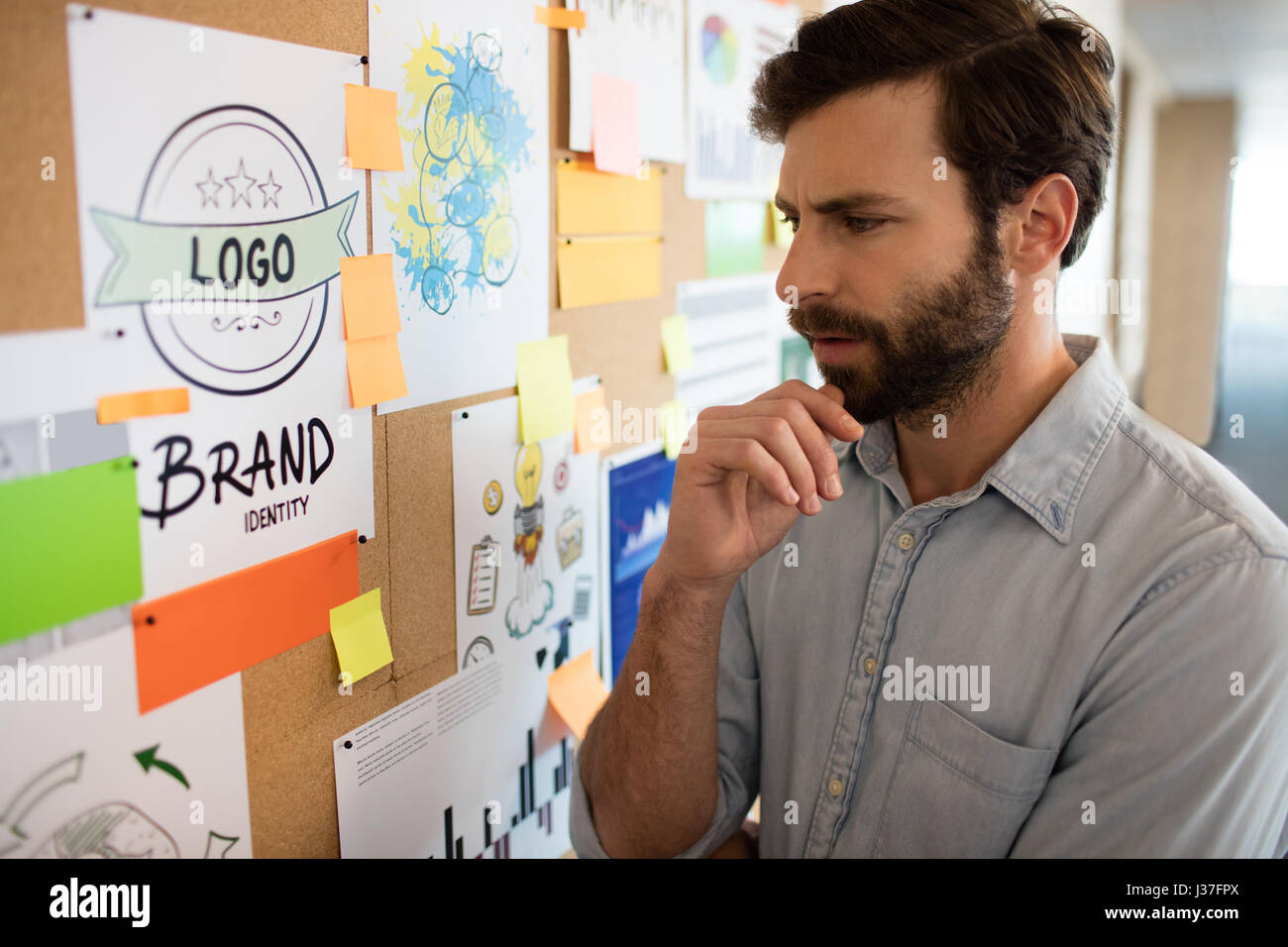 Thoughtful businessman looking at chart in office Stock Photo - Alamy