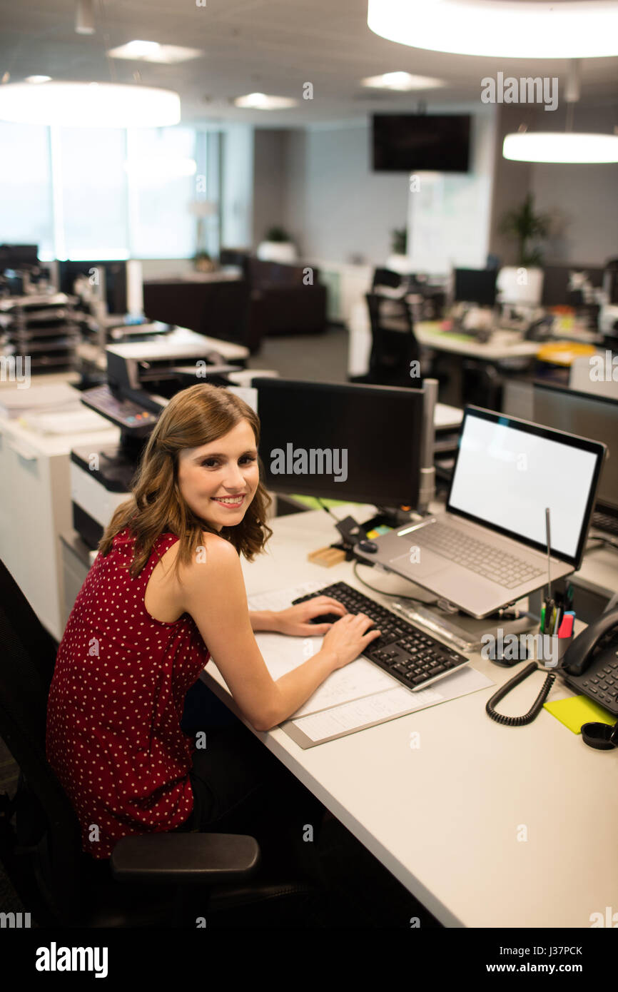 Portrait of smiling businesswoman using computer in offic Stock Photo ...