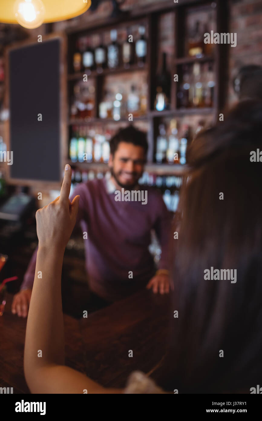 Woman asking for a drink to bar tender at pub Stock Photo Alamy