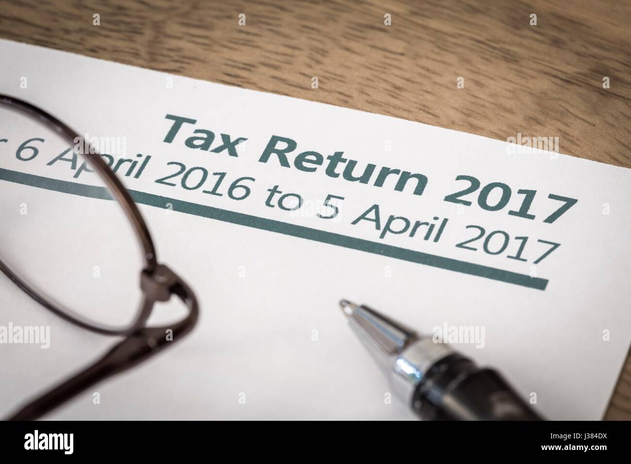 UK Income tax return form for 2017 on a desk with pen and glasses Stock Photo
