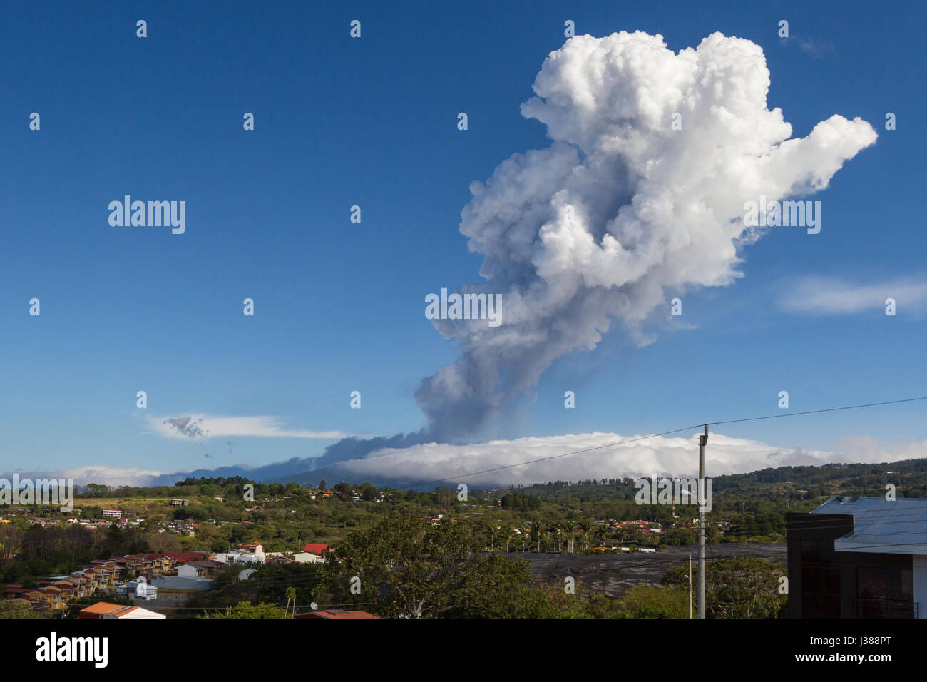 Heredia, Costa Rica - April 14: Plum of steam and ash from volcanic activity towering above the Poas Volcano and surrounding neighborhoods. April 14 2 Stock Photo