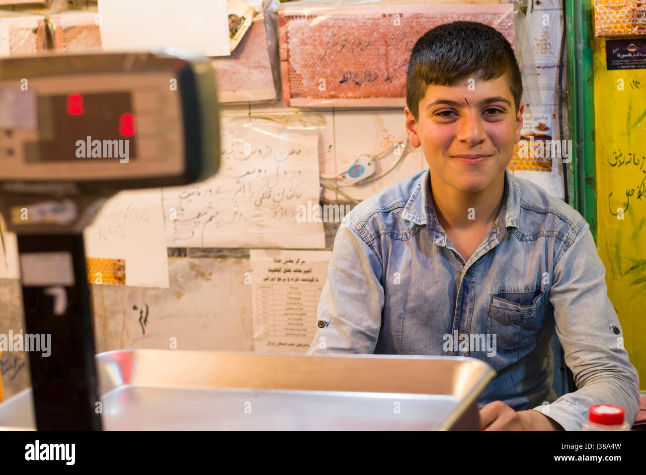 Ardabil- IRAN-September 21, 2016 Happy Teenager Seller Assistant in Honeycomb Store Stock Photo