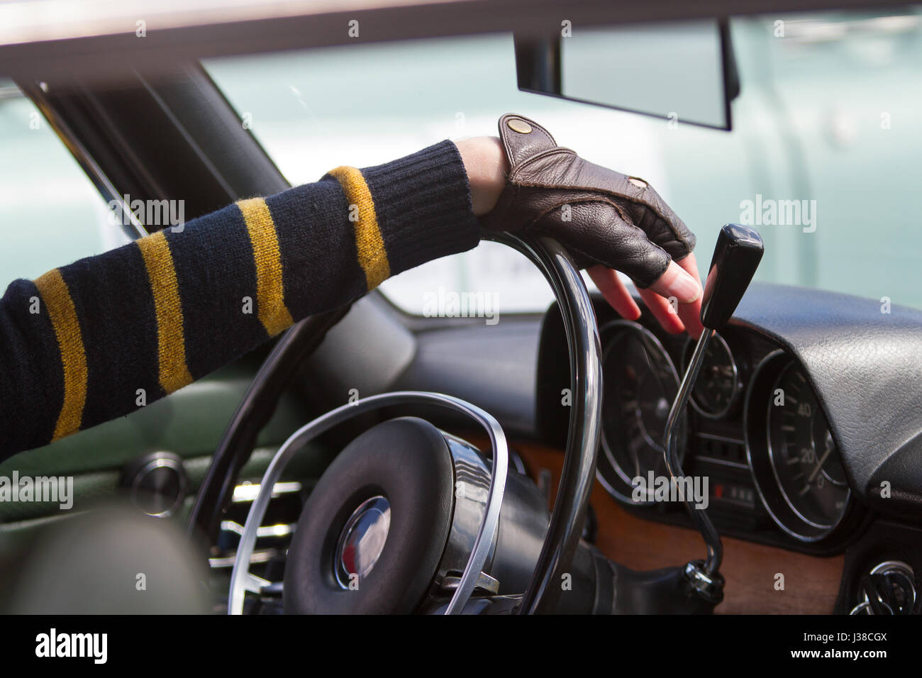 the driver keeps hands in leather gloves on the steering wheel of his