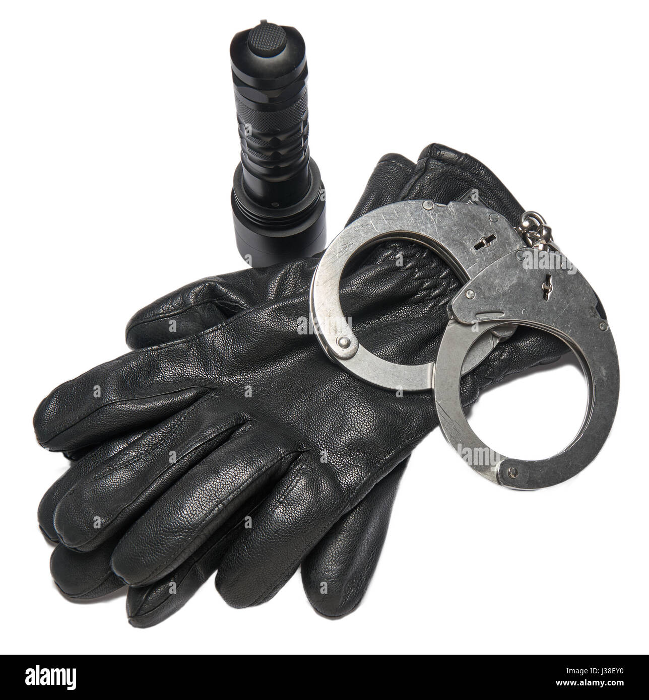 German police handcuffs, leather gloves and a torchlight isolated on white background. Stock Photo