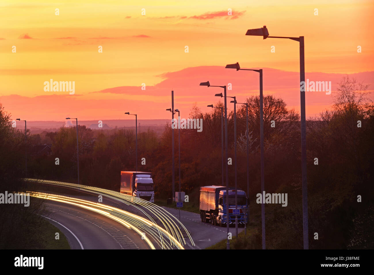 traffic light trails passing sleeping lorry drivers in roadside refuge at sunset selby yorkshire united kingdom Stock Photo