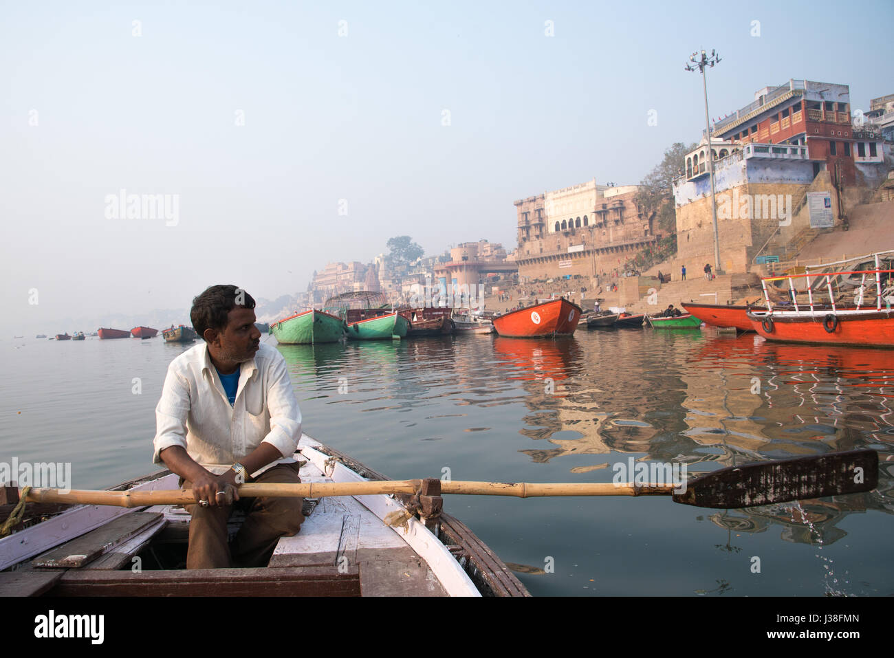 Man rowing a boat on the river Ganges in Varanasi, India Stock Photo