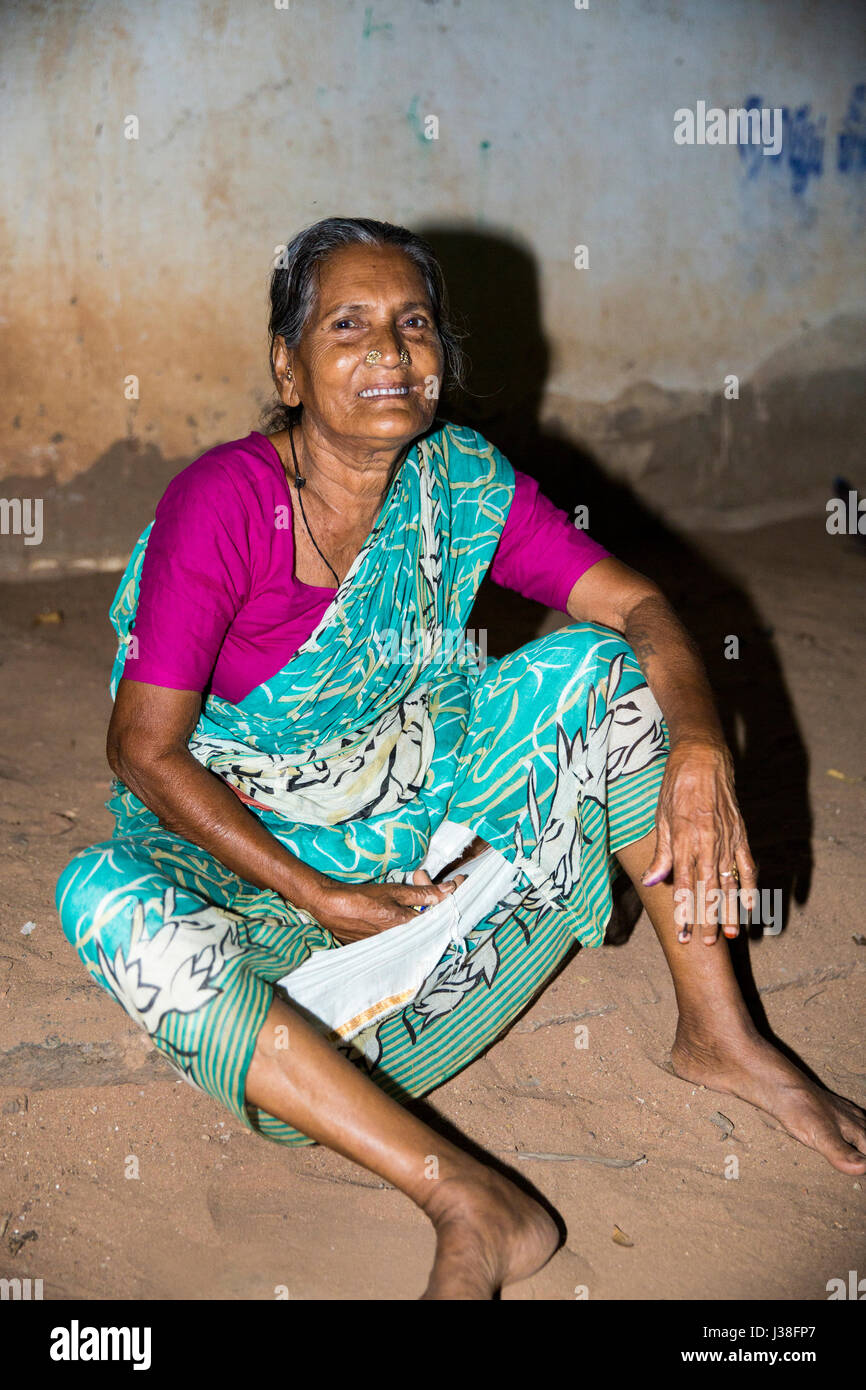 Documentary editorial image. Pondicherry, Tamil Nadu, India - April 24 2014. Very poor woman sitting in the street during the night. Poverty Stock Photo