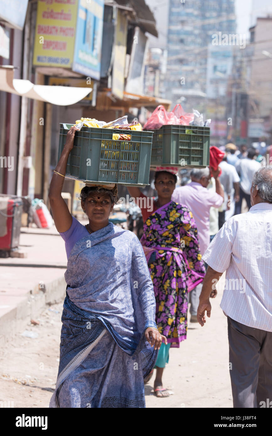 Women carrying goods on their heads in front of Meenakshi Temple, Madurai, India Stock Photo