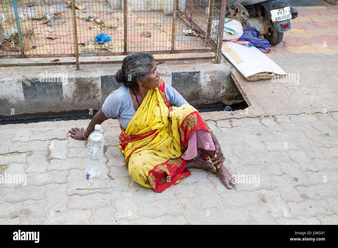 Documentary editorial image. Pondicherry, Tamil Nadu, India - June 23 2014. Very poor woman sitting in the street asking for food Poverty Stock Photo