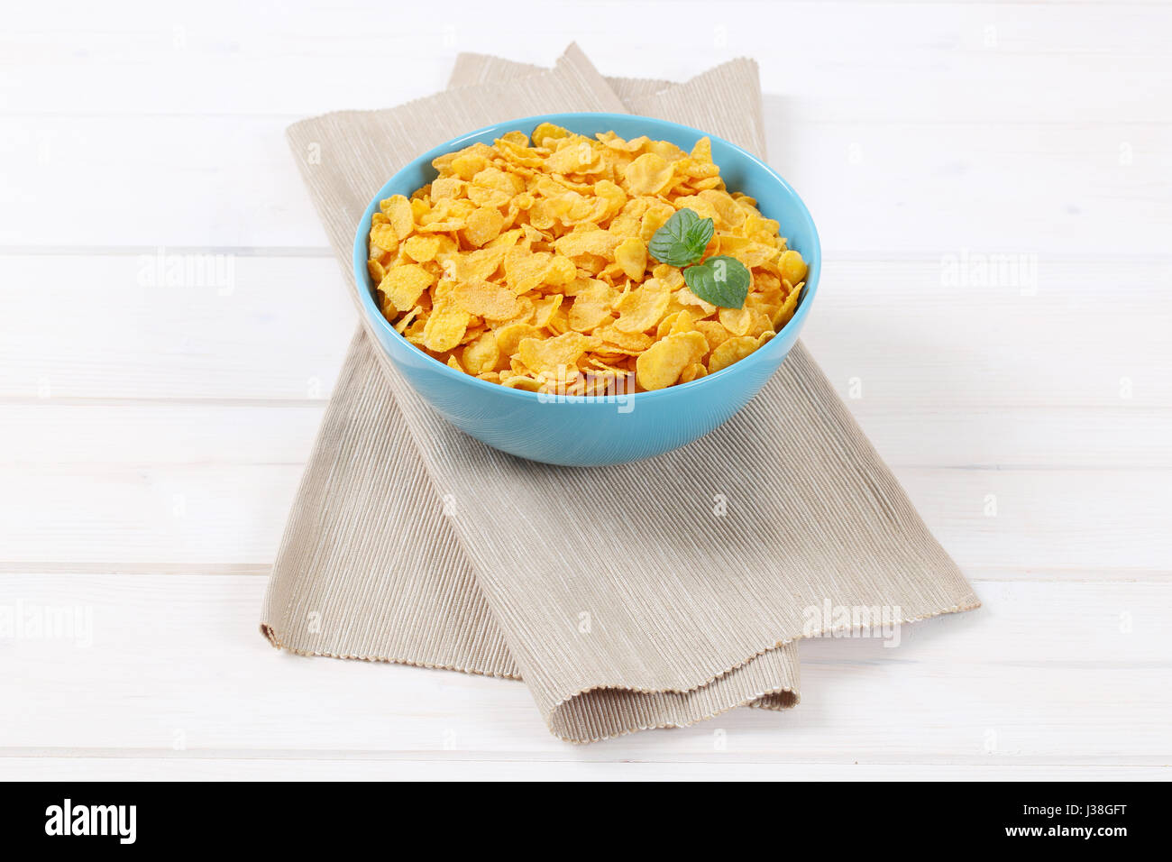 bowl of corn flakes on beige place mat Stock Photo