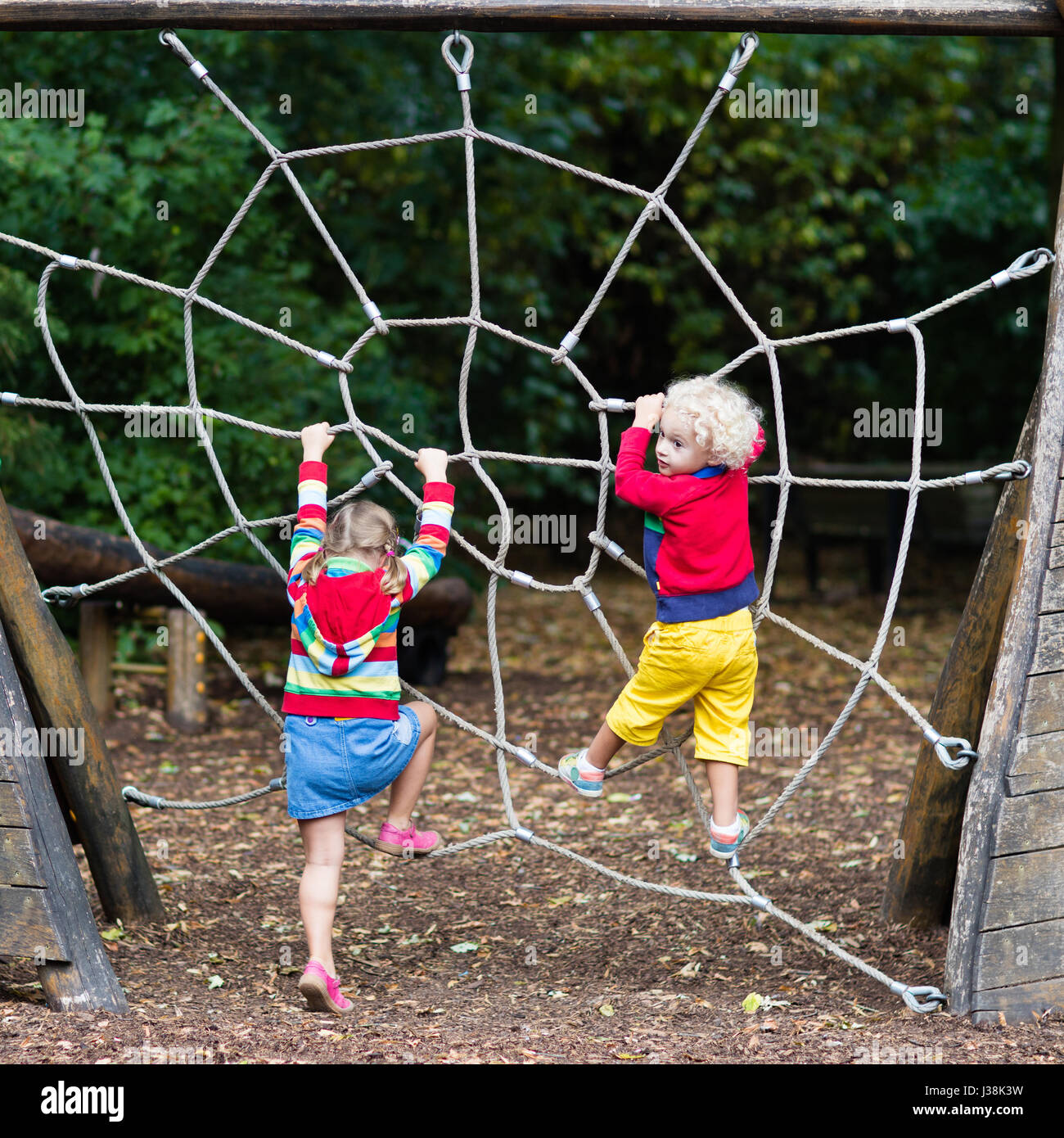 Active children playing on climbing net at school yard playground. Kids  play and climb outdoors on sunny summer day. Cute girl and boy on nest  swing a Stock Photo - Alamy