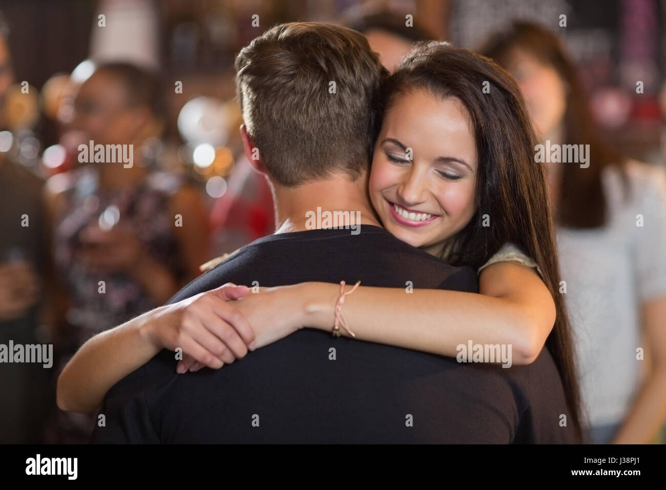Happy woman hugging her boyfriend in bar Stock Photo - Alamy