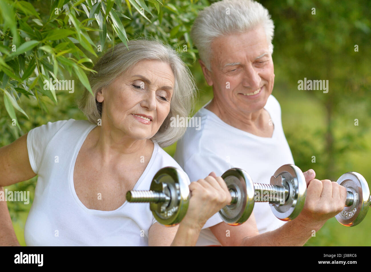 Beautiful elderly couple with dumbbells Stock Photo