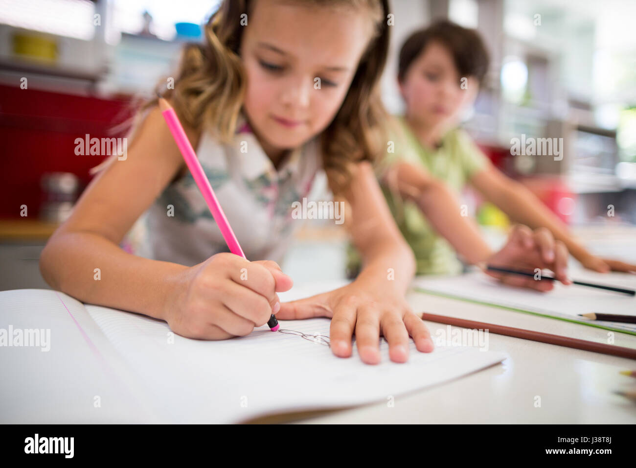 Siblings doing homework in kitchen at home Stock Photo Alamy