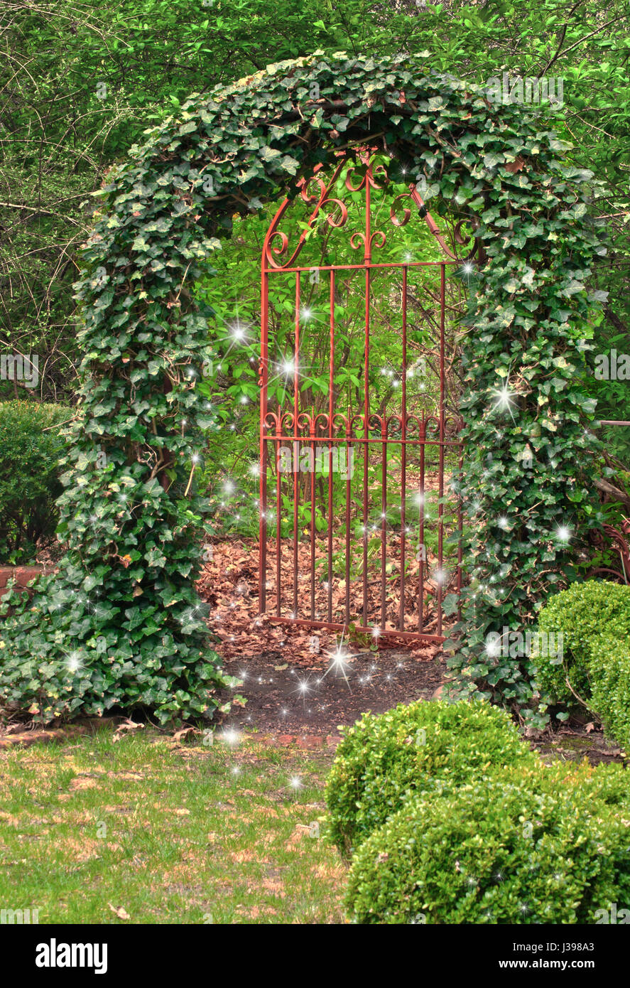 Wrought Iron Gate covered in ivy and fairies dancing in garden Stock Photo