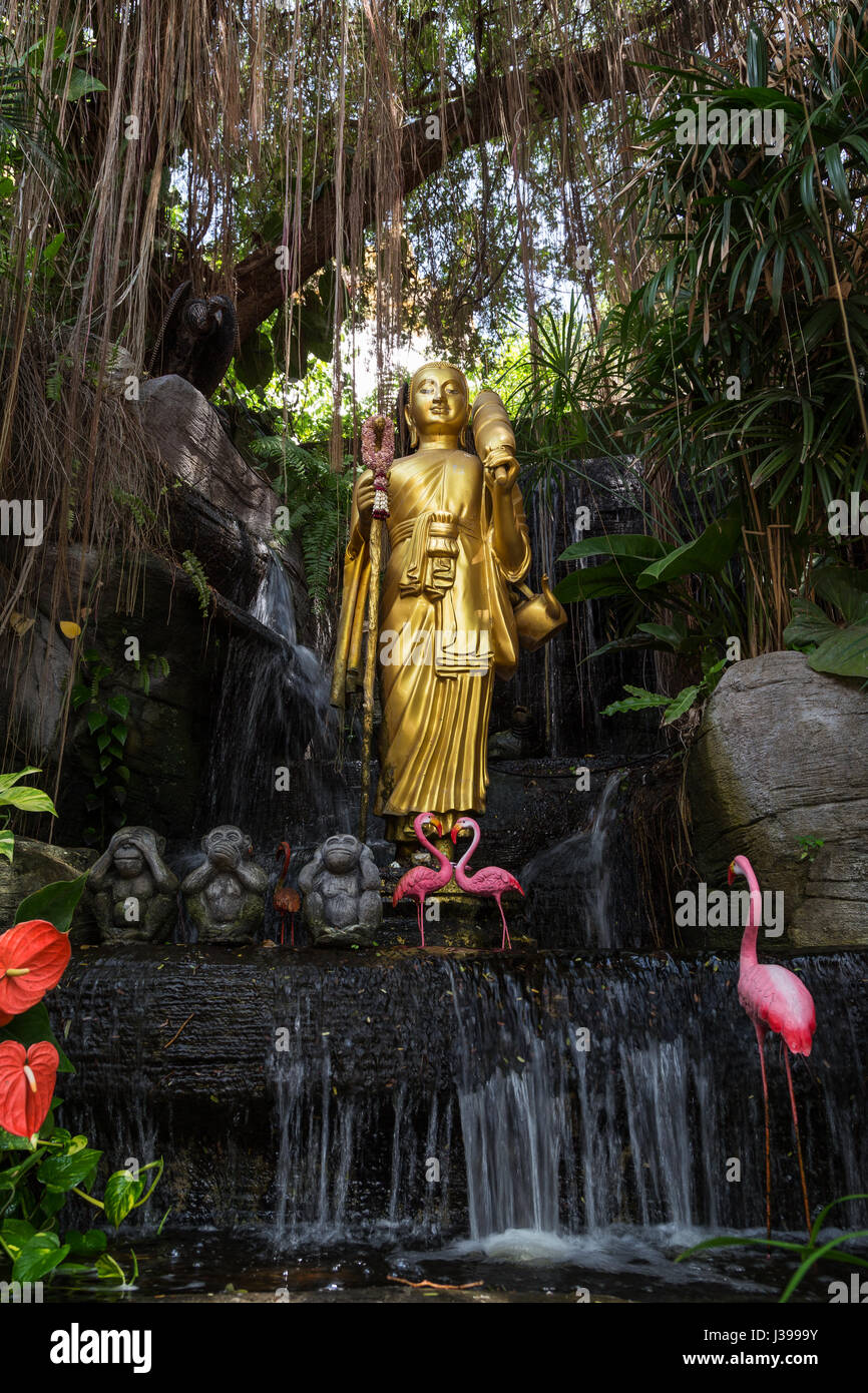 Golden Buddha statue and small artificial waterfall at the Golden Mount at Wat Saket in Bangkok, Thailand. Stock Photo