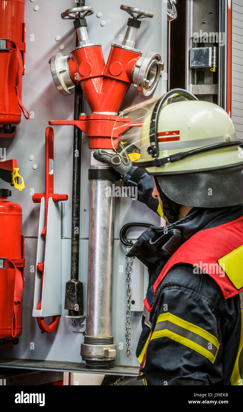 Firefighter in action with a professional extinguisher - HDR Stock Photo