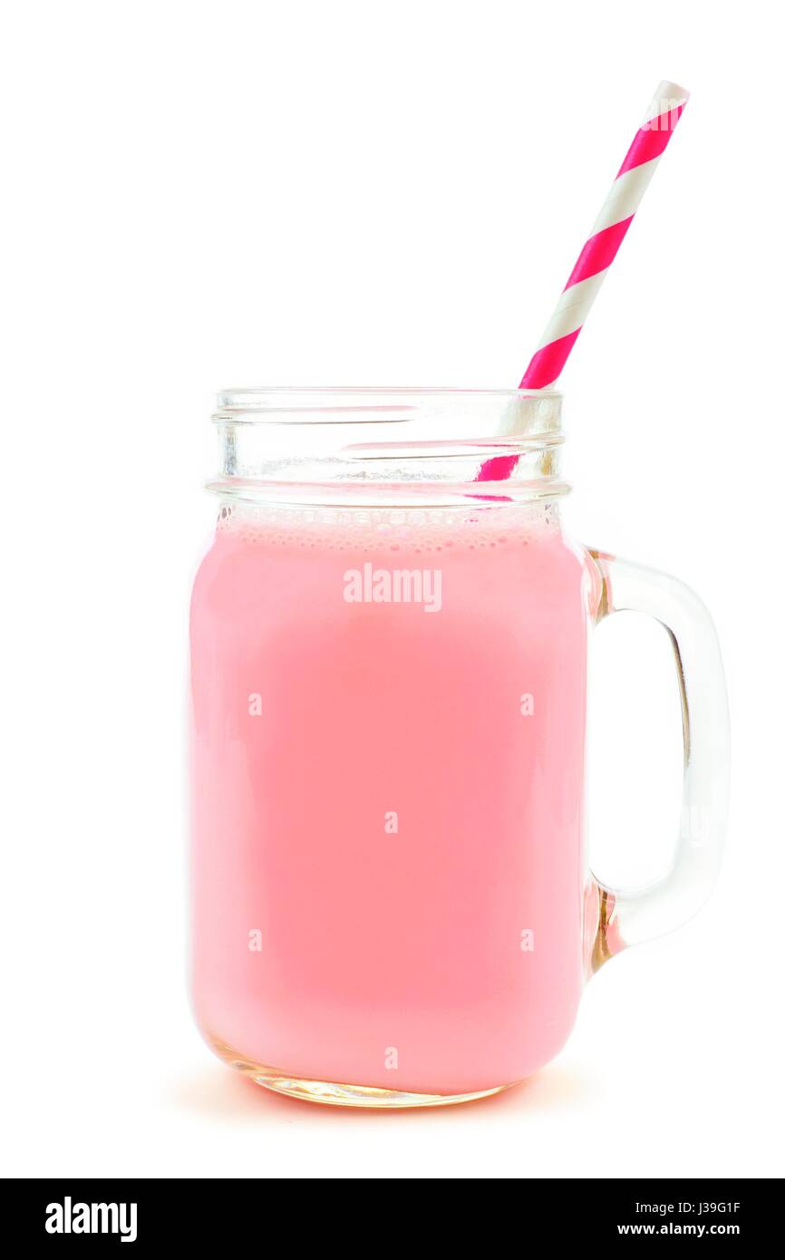 Strawberry milk in a glass mason jar mug with striped paper straw isolated on a white background Stock Photo