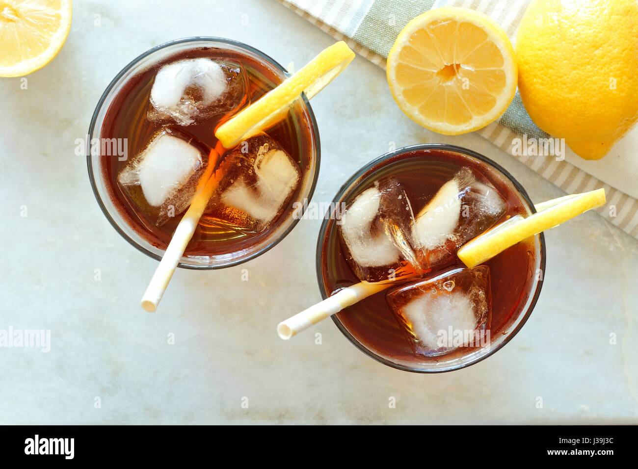 Two glasses of iced tea with lemons, overhead view on a white marble background Stock Photo