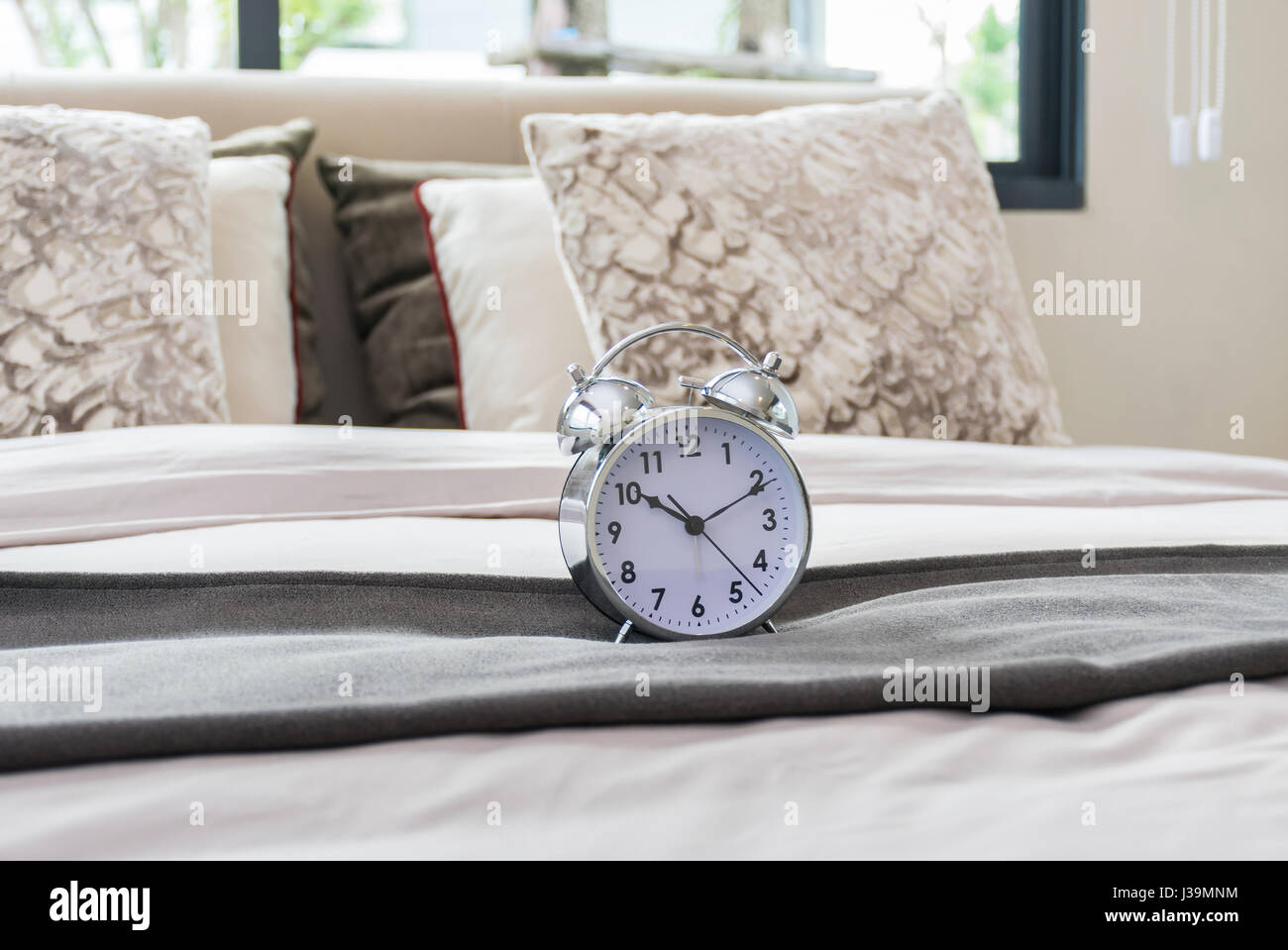 classical alarm clock on bed Stock Photo Alamy