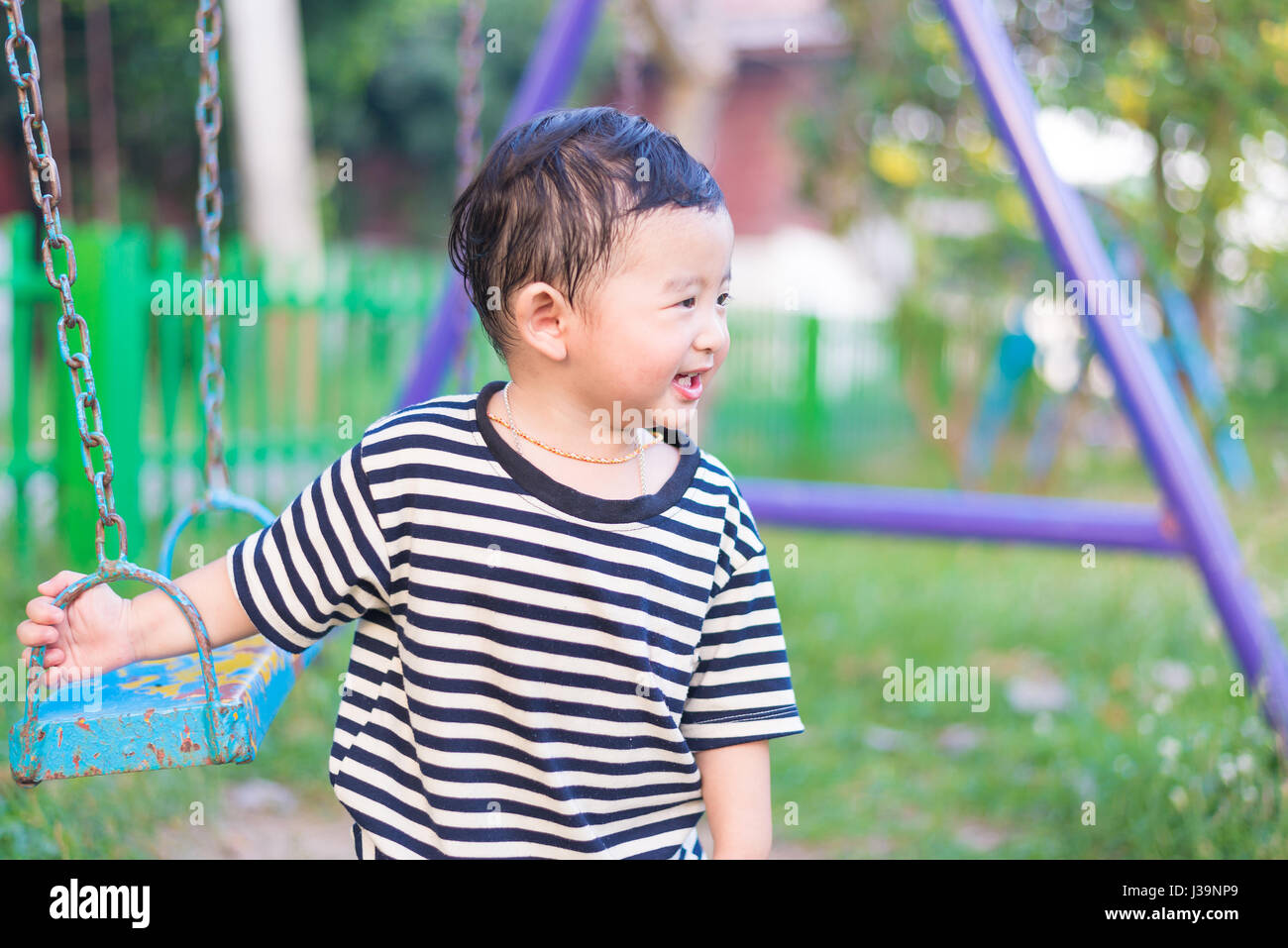 Young Asian Boy Play A Iron Swinging At The Playground Under