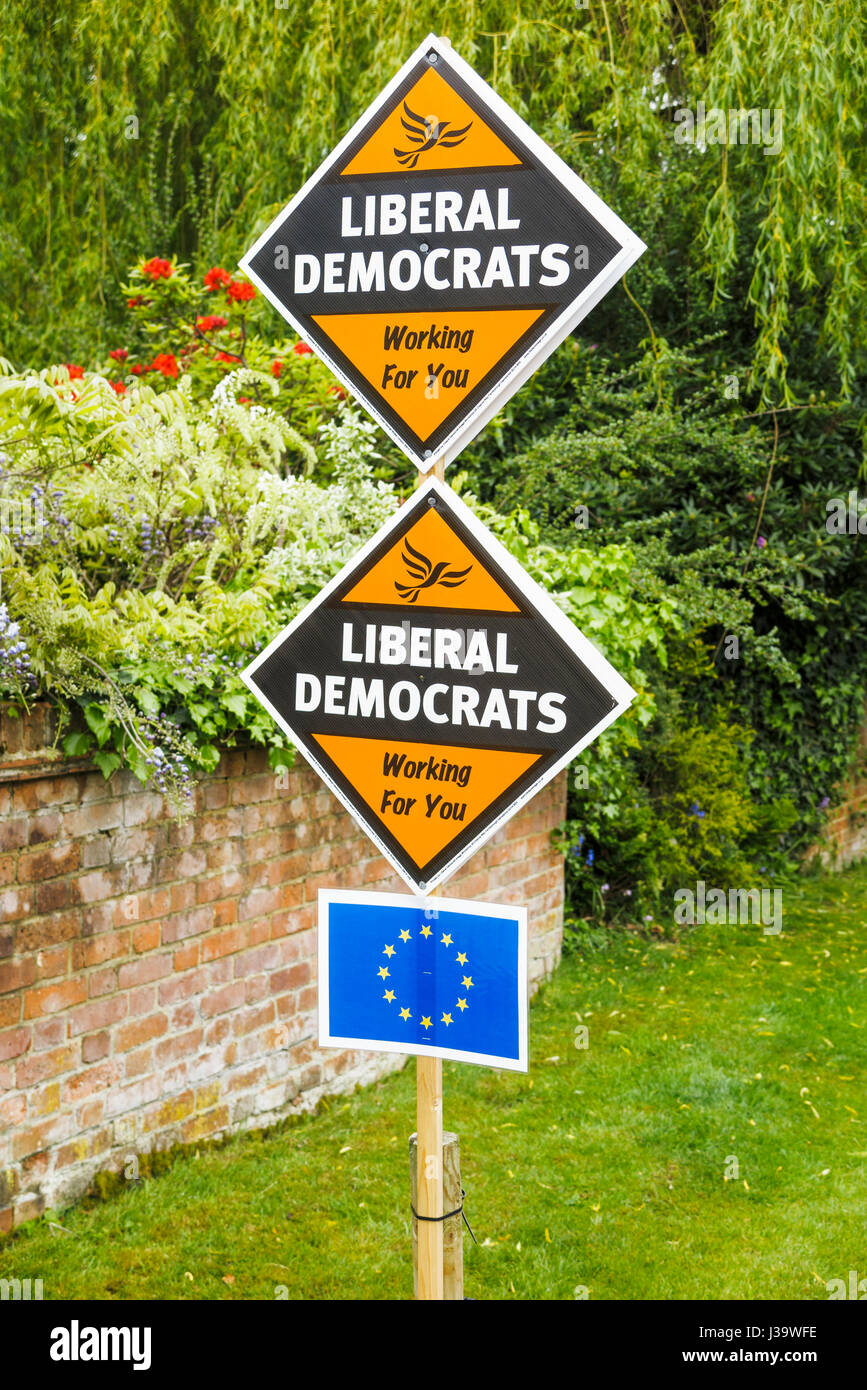 Roadside orange diamond-shaped boards, placards or signs on grass verge supporting and electioneering for the Liberal Democrat political party Stock Photo