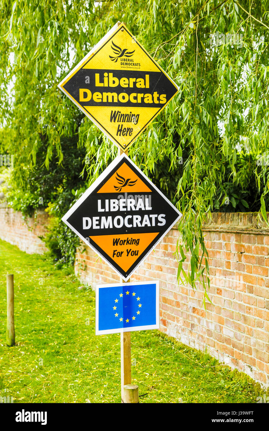 Roadside orange diamond-shaped boards, placards or signs on grass verge supporting and electioneering for the Liberal Democrat political party Stock Photo