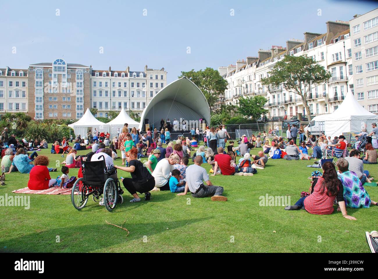 The audience sit on the grass at the annual St.Leonards Festival at St.Leonards-on-Sea in East Sussex, England on July 12, 2014. Stock Photo