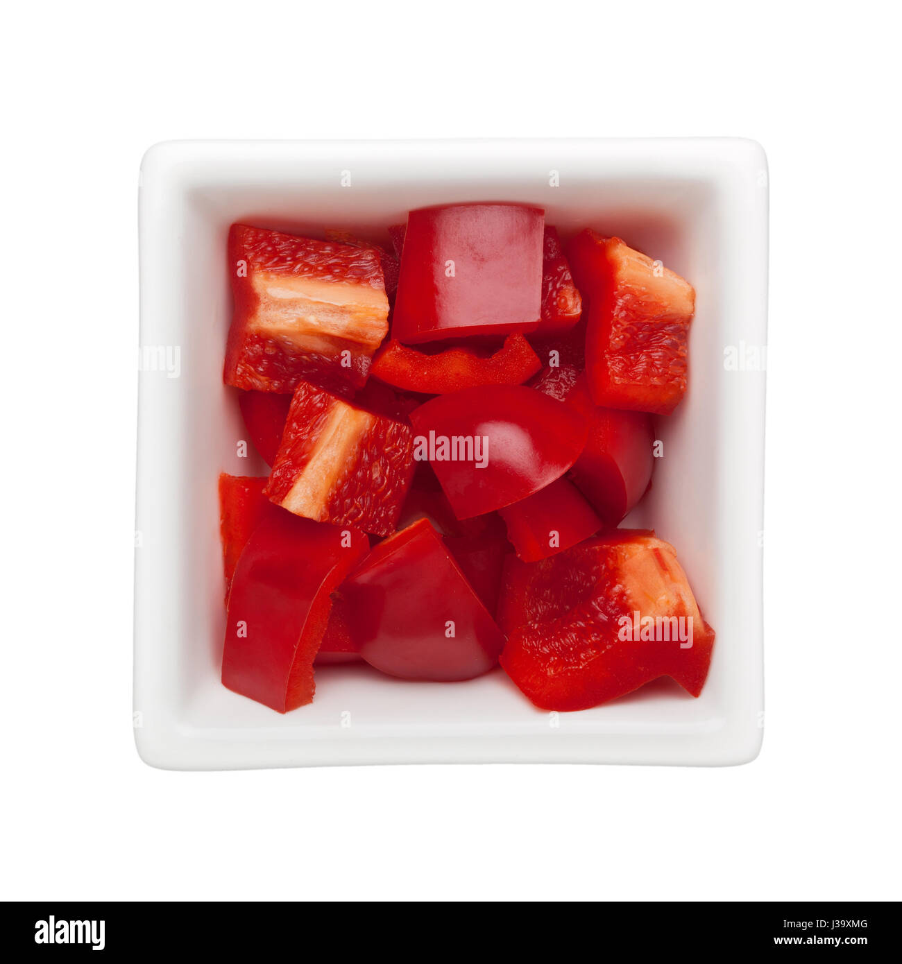 Diced red bell pepper in a square bowl isolated on white background