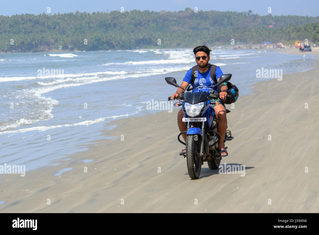 A young man rides his motorbike along Muzhappilangad beach, Kerala’s only drive-in beach, Kannur(Cannanore), Kerala, South India, South Asia. Stock Photo