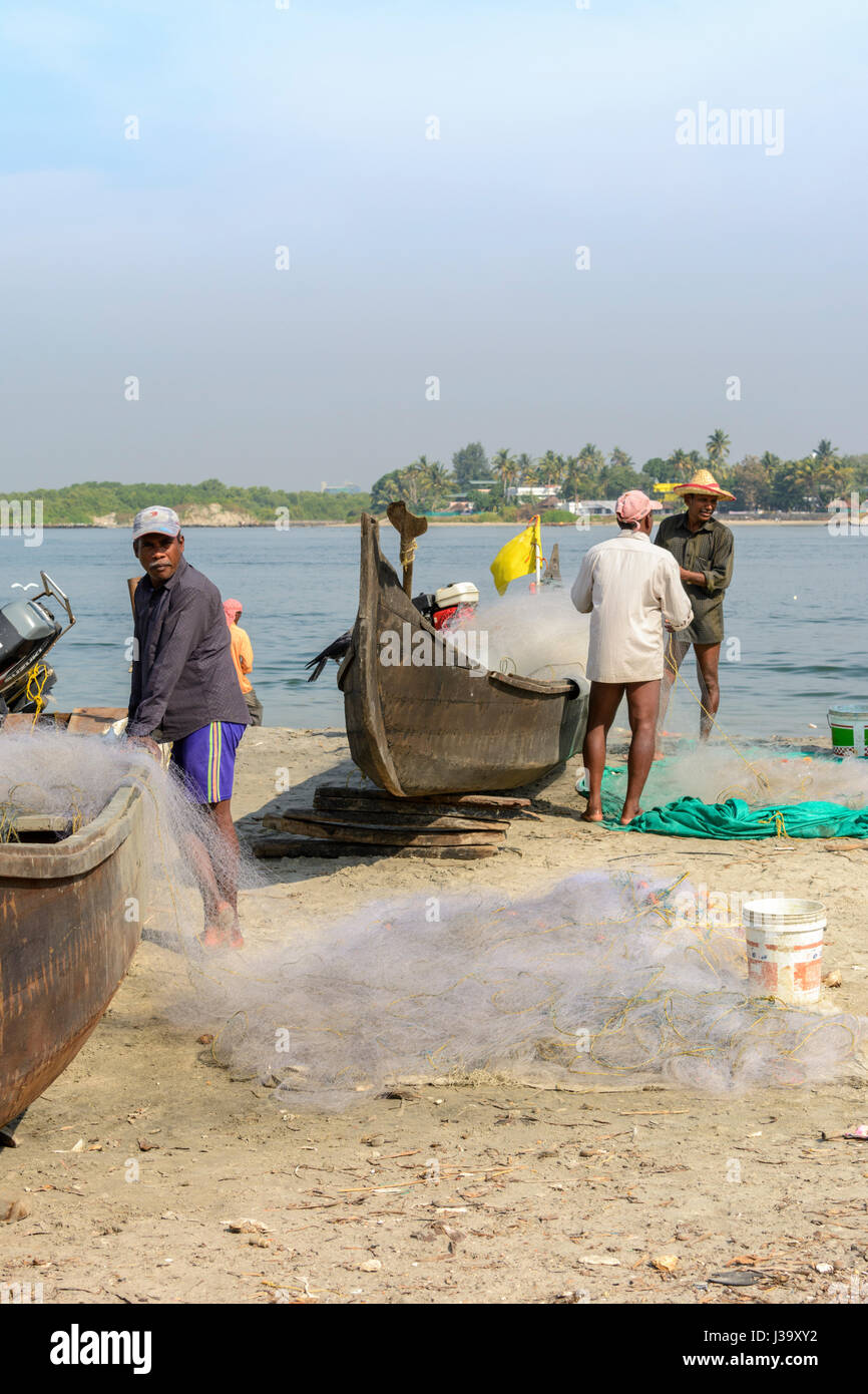 Keralan fishermen checking their nets on the shore in Kochi (Cochin), Kerala, South India, South Asia Stock Photo