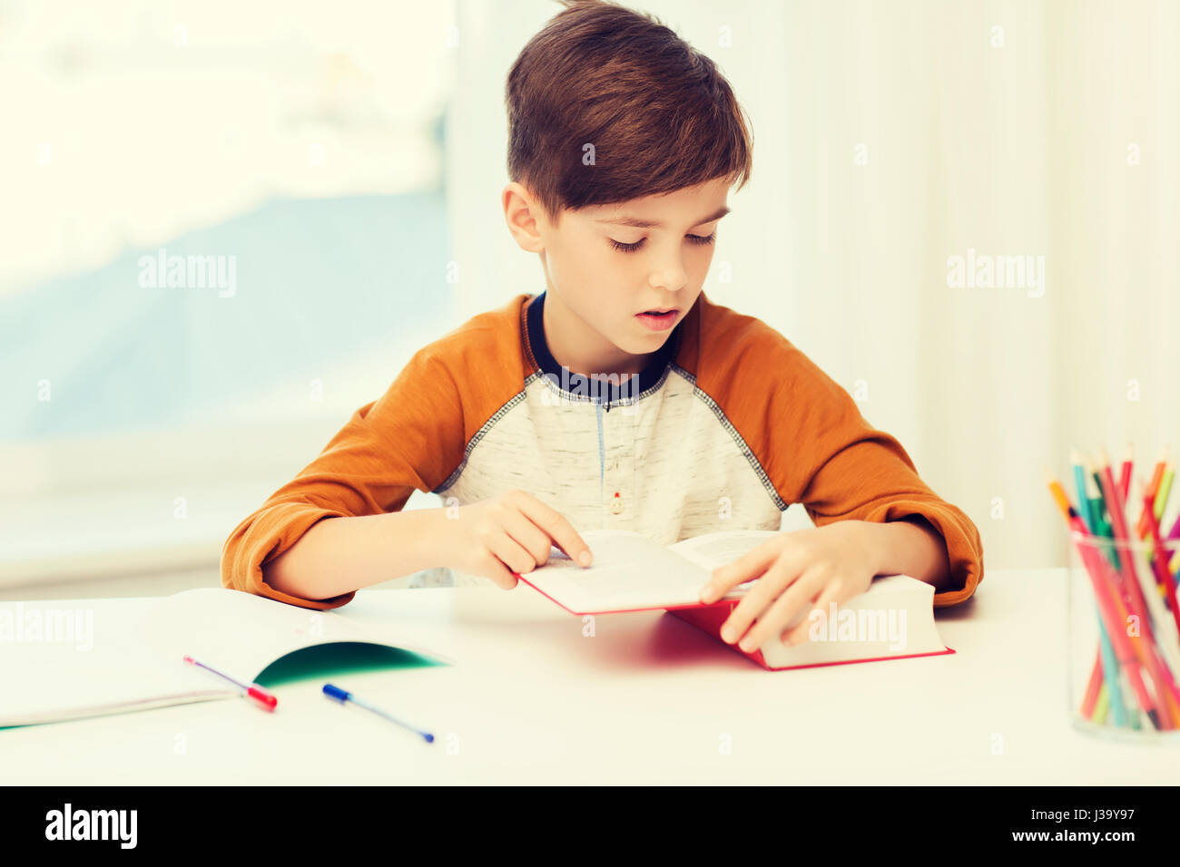 student boy reading book or textbook at home Stock Photo Alamy