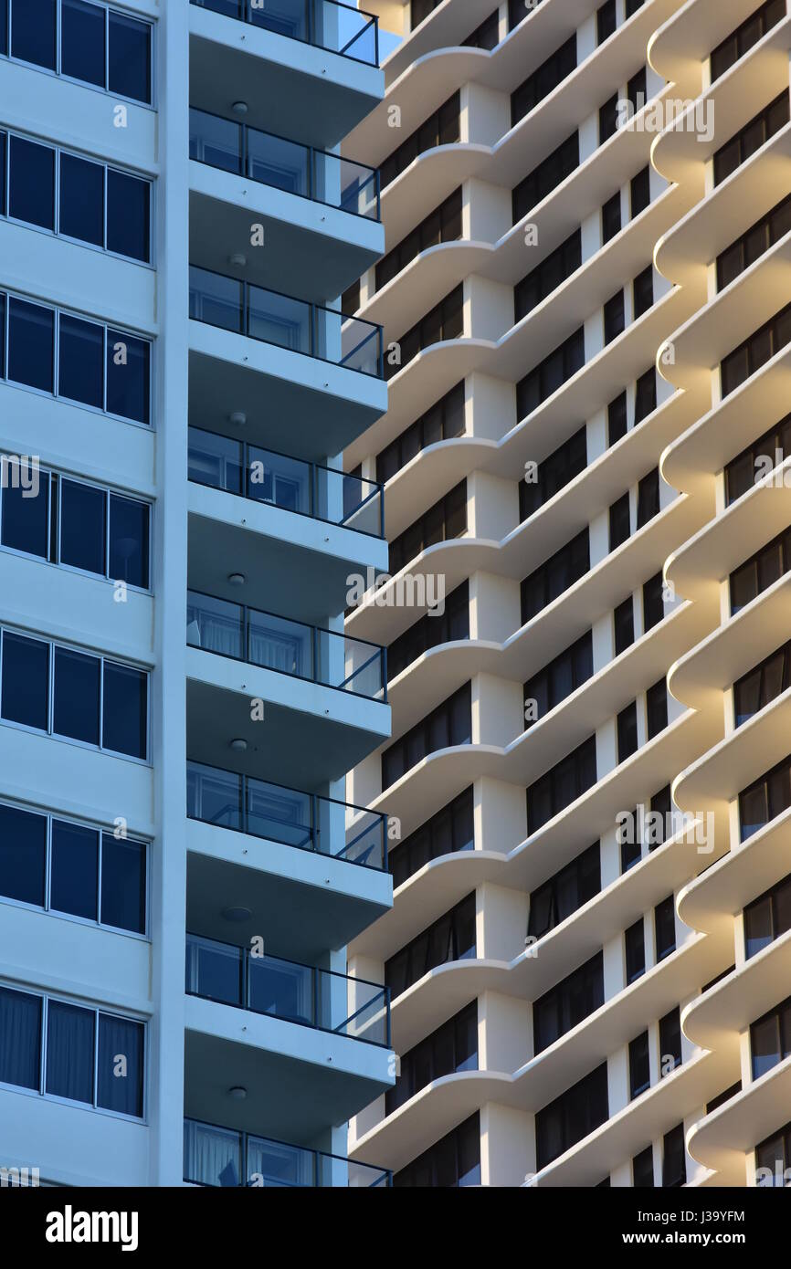 Exterior walls of tall apartment buildings covered with windows and balconies. Stock Photo