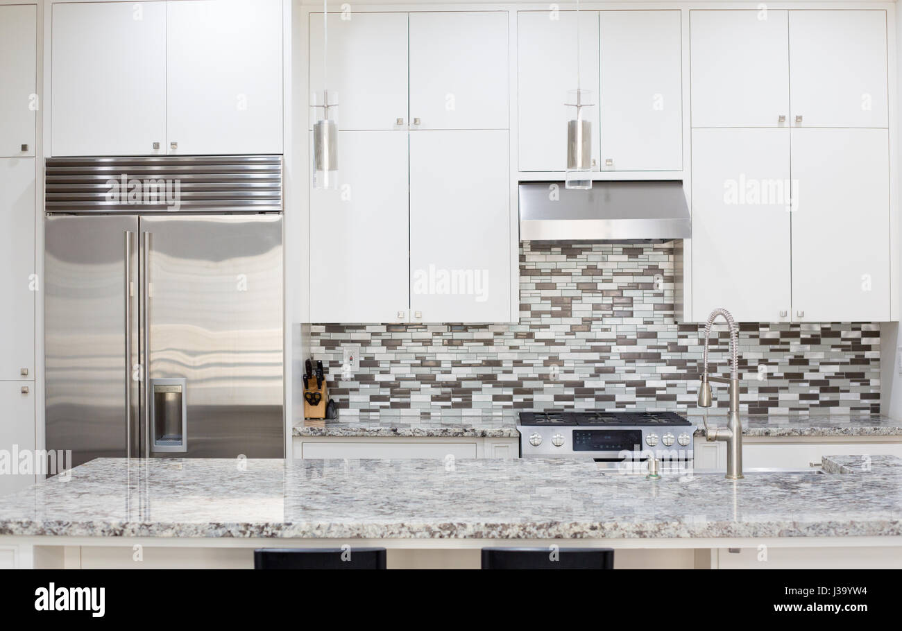 Snapshot of interior modern kitchen with granite countertop island and smart refrigerator Stock Photo