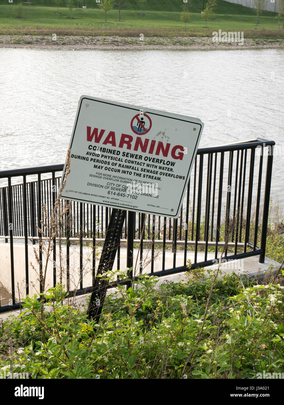 Water pollution warning on storm sewer overflow. Scioto River, Columbus, Ohio. Stock Photo