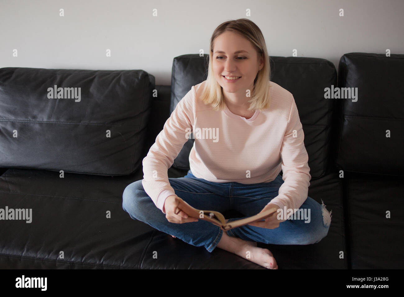 Young woman with planner. Portrait in the interior, on the couch at ...