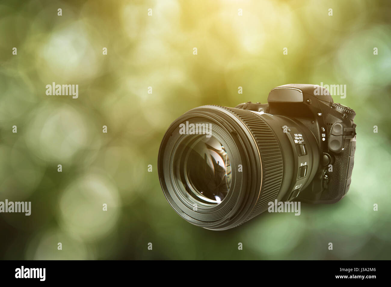 DSLR Camera on green background Stock Photo