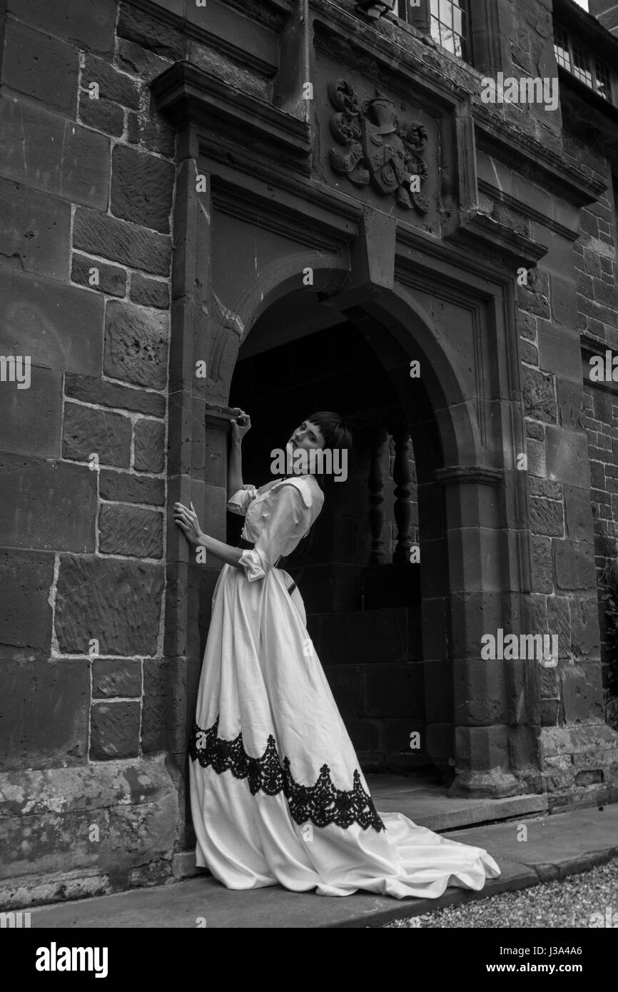 Beautiful Elegant Woman modelling ball gown at manor location, UK Black and white Stock Photo