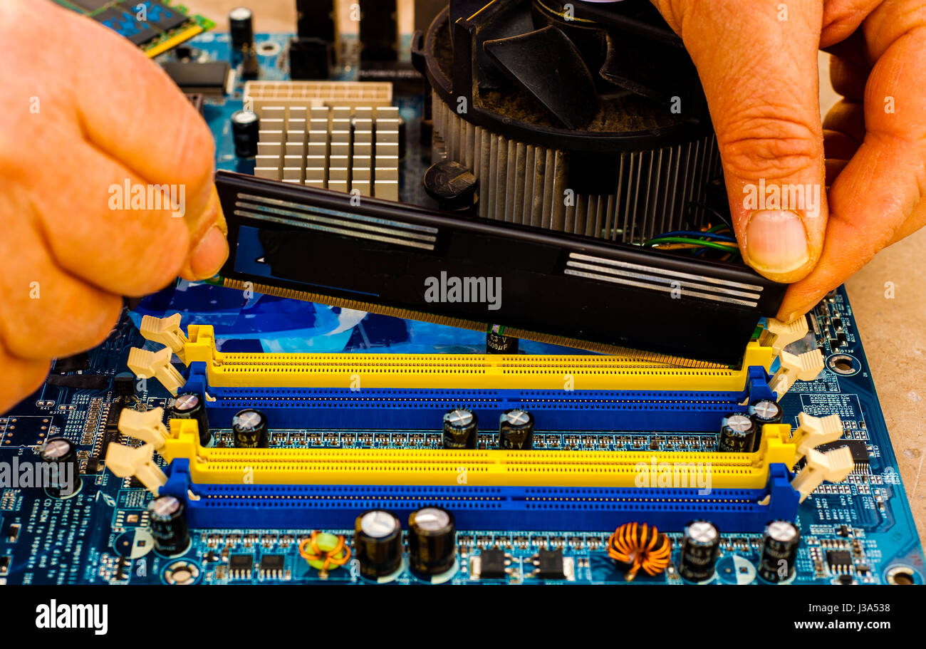 Put computer memory DDR RAM in the slot of motherboard Stock Photo