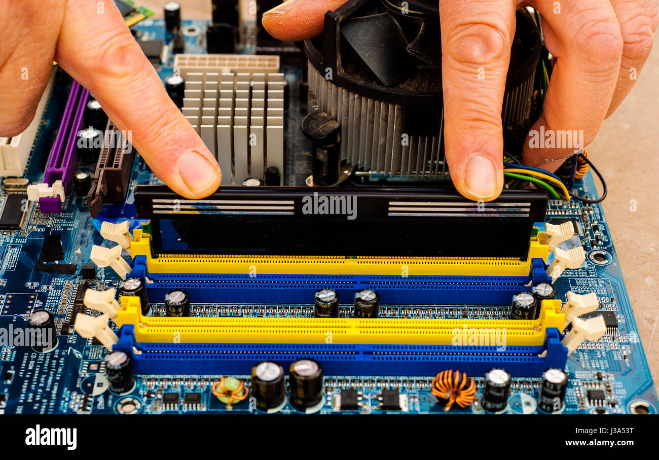 Put computer memory DDR RAM in the slot of motherboard Stock Photo