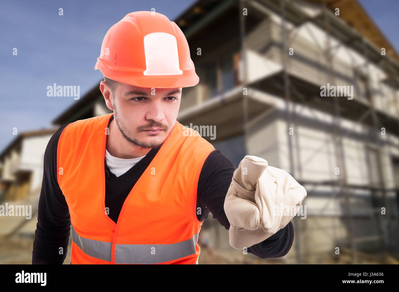 Successful male builder using an imaginary screen and pointing it ...