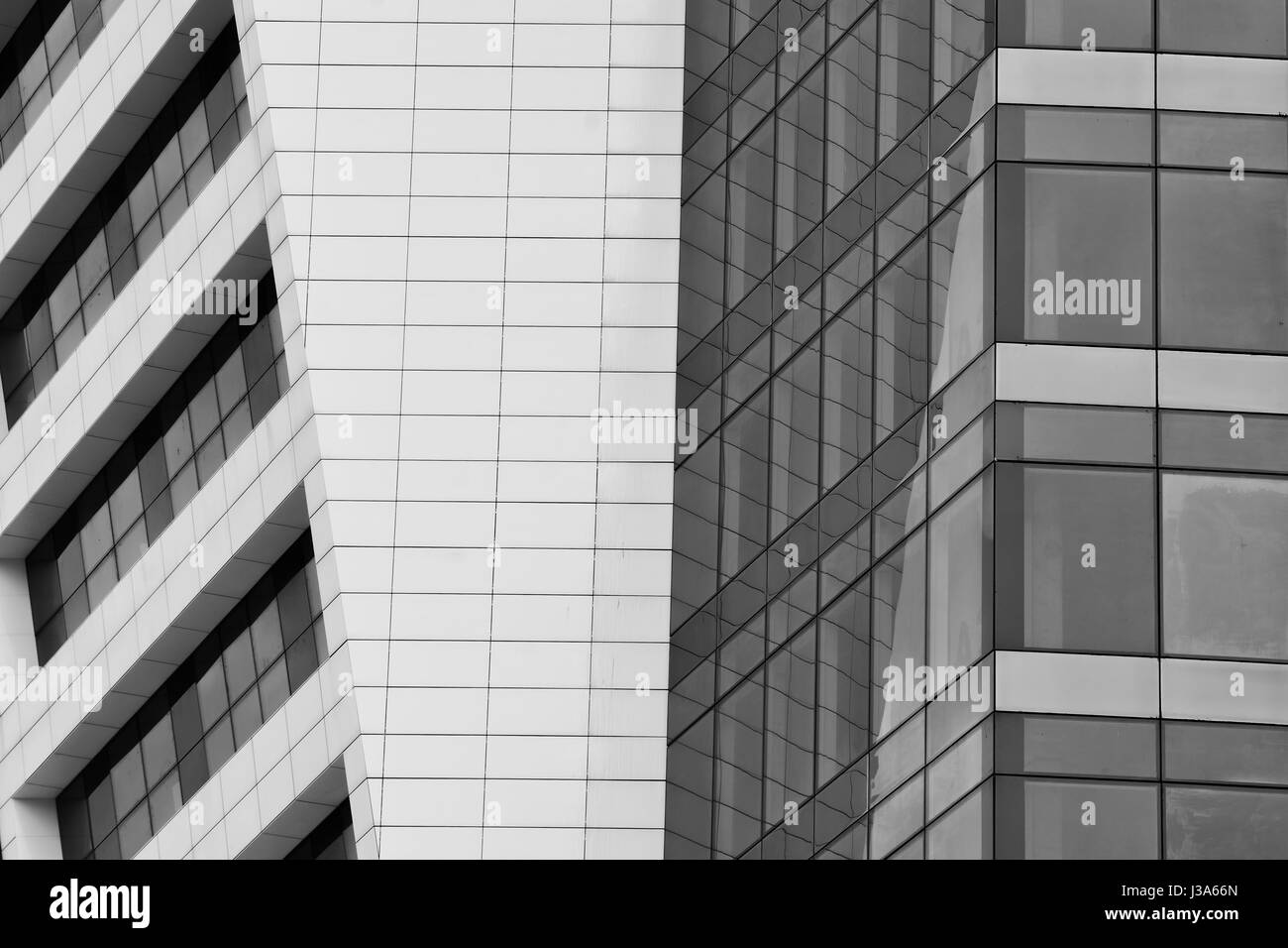 Glass surface of skyscrapers view in district of business centers with reflection on it, black and white Stock Photo