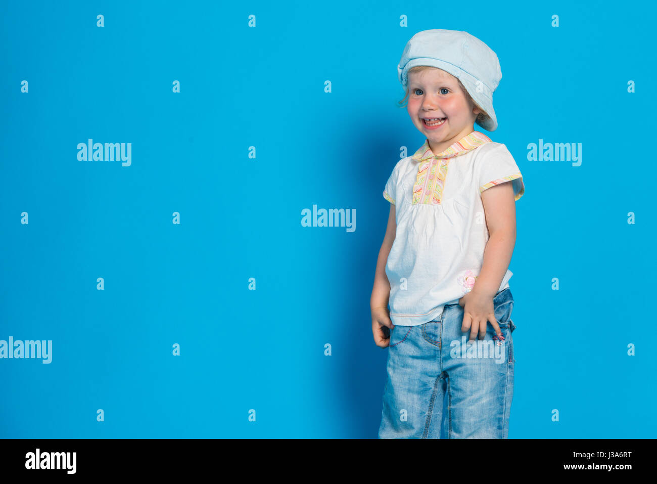 Portrait of beautiful little girl against blue background Stock Photo ...