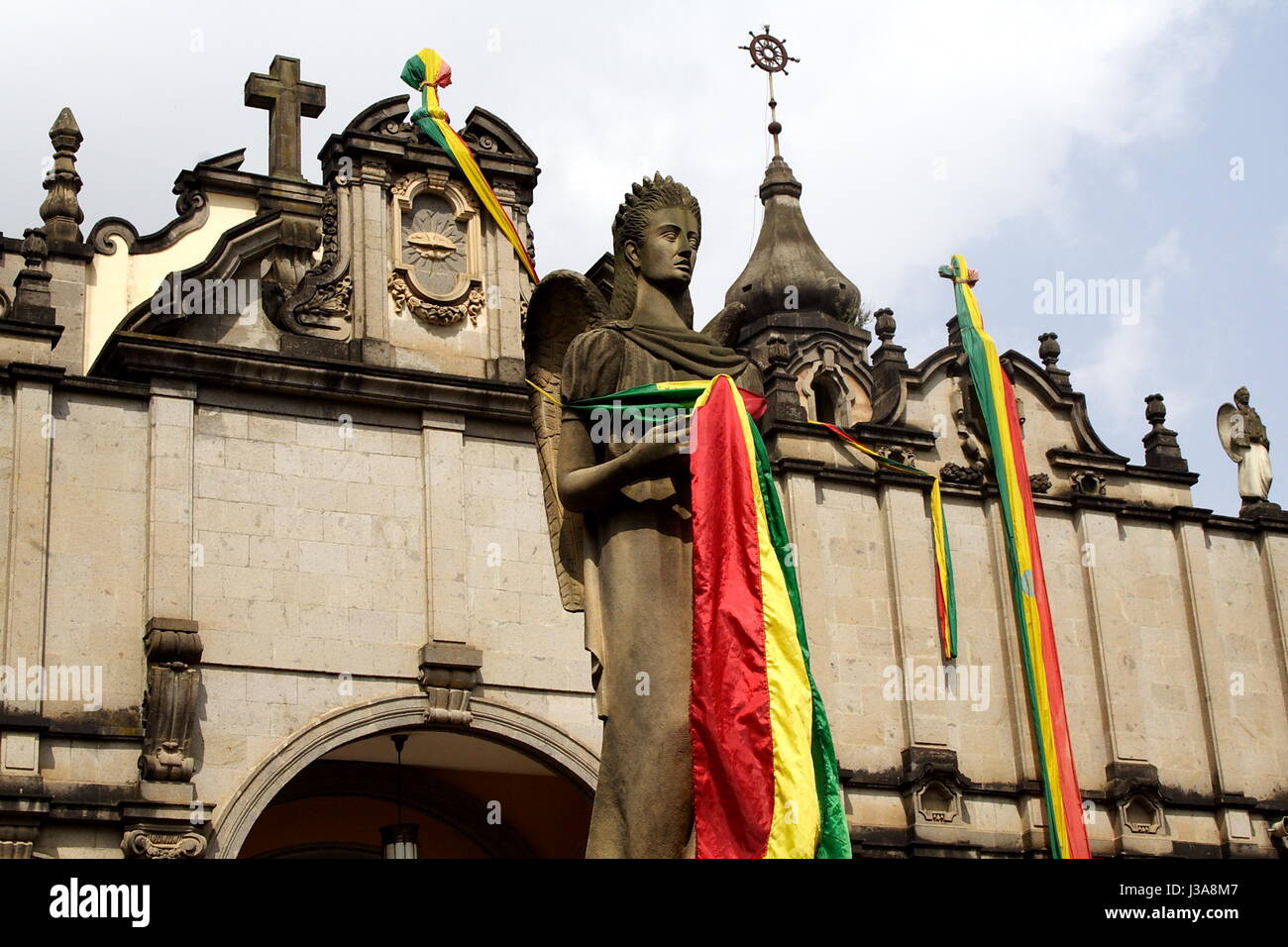 An angel statue draped in the Ethiopian national colours, standing in front of Holy Trinity Cathedral, Addis Ababa, Ethiopia. Stock Photo