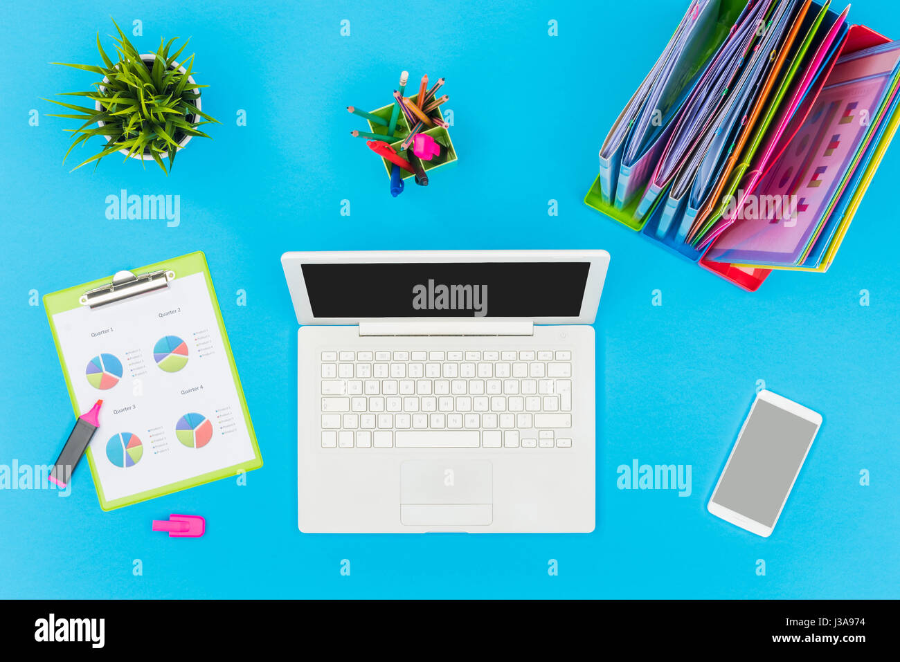 Blue office table with laptop and documents Stock Photo Alamy
