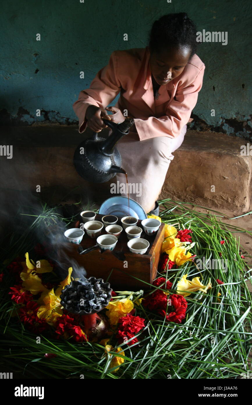 Ethiopian woman performing the traditional coffee ceremony in her home in the Kaffa region of Ethiopia, where the coffee bean oriiginated. Stock Photo