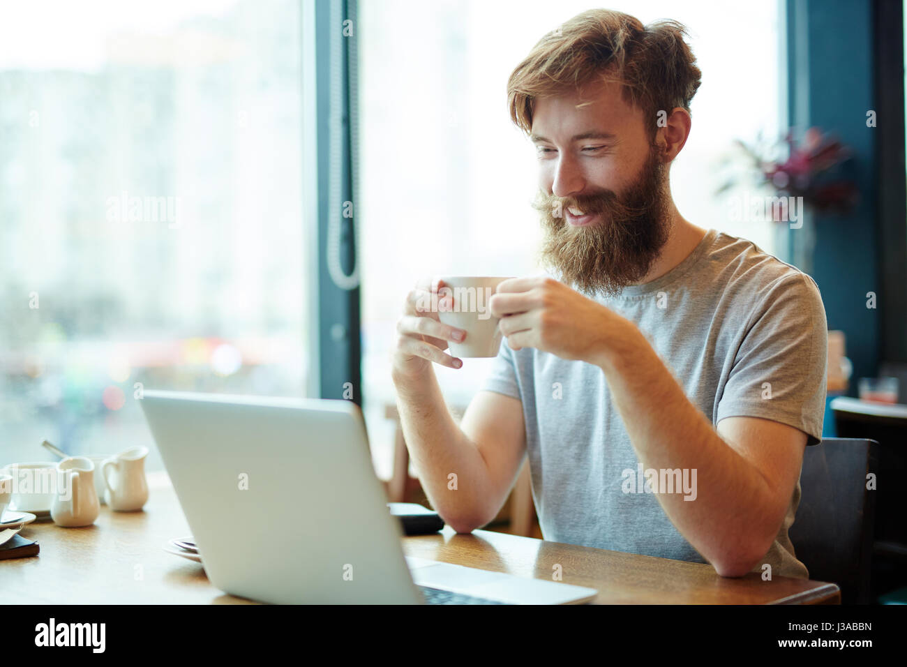 Handsome Businessman Using Laptop in Cafe Stock Photo