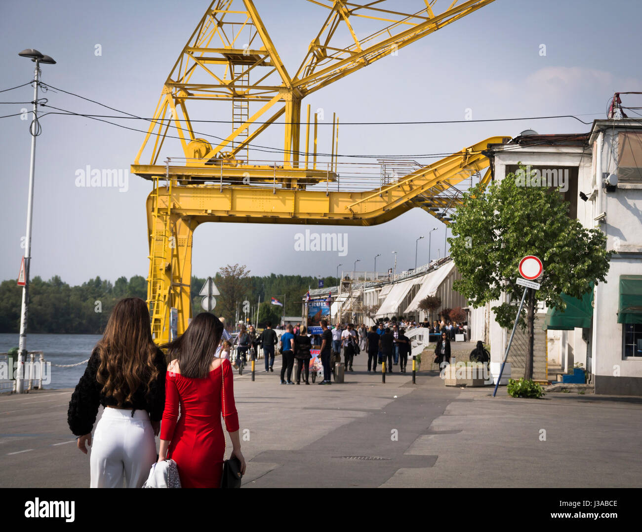 Girls walking towards group of people at Belgrade's customs port. Stock Photo