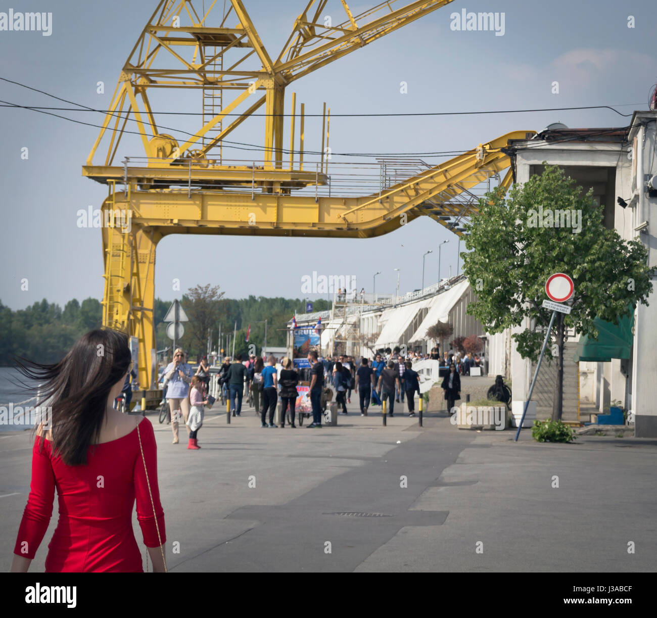 Girl walking towards group of people at Belgrade's customs port. Stock Photo